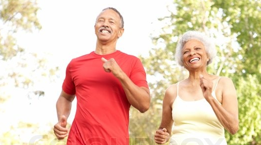 adultos mayores afrodecendientes haciendo ejercicio al aire libre mientras sonríen