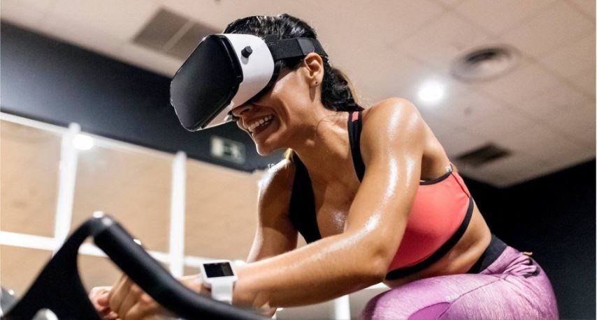 mujer realizando spinning usando lentes de realidad virtual