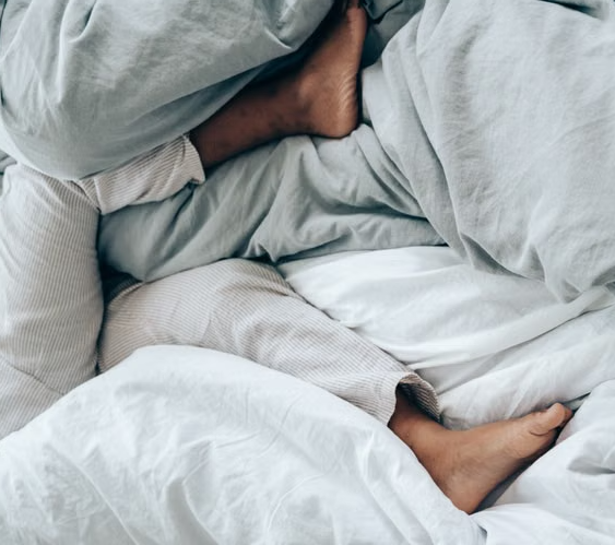 vista de de unas piernas relajadas sobre una cama confortable